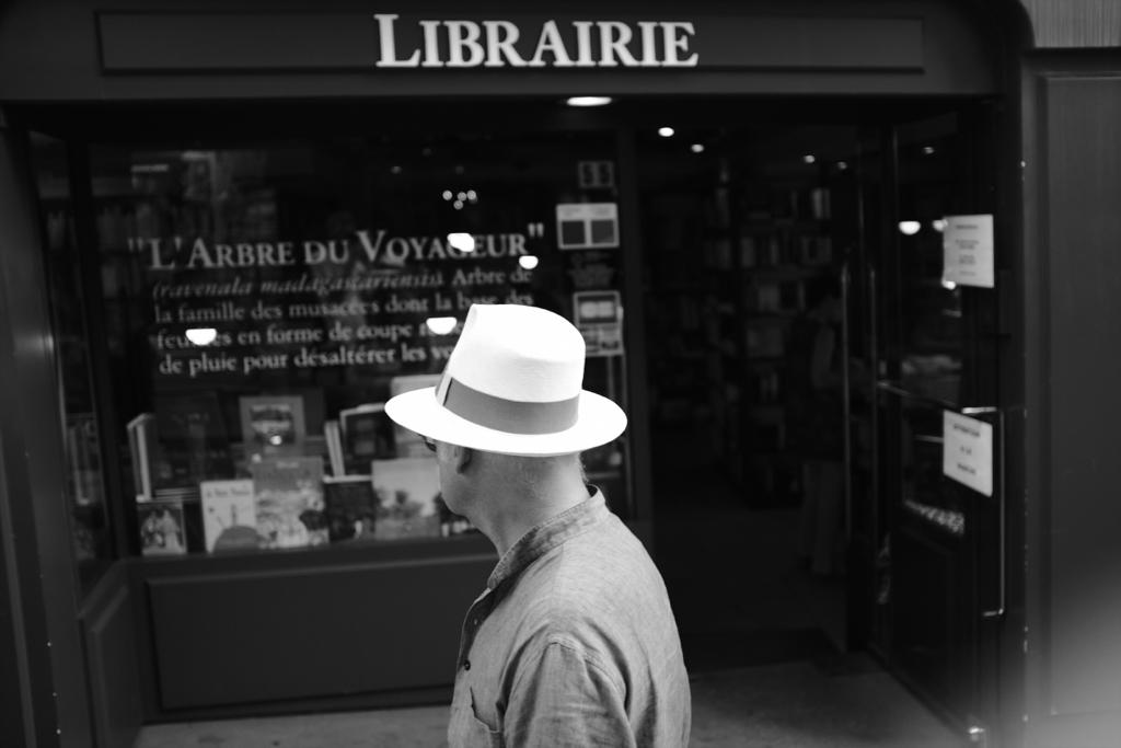 photo de rue photographie homme avec chapeau devant librairie noir et blanc