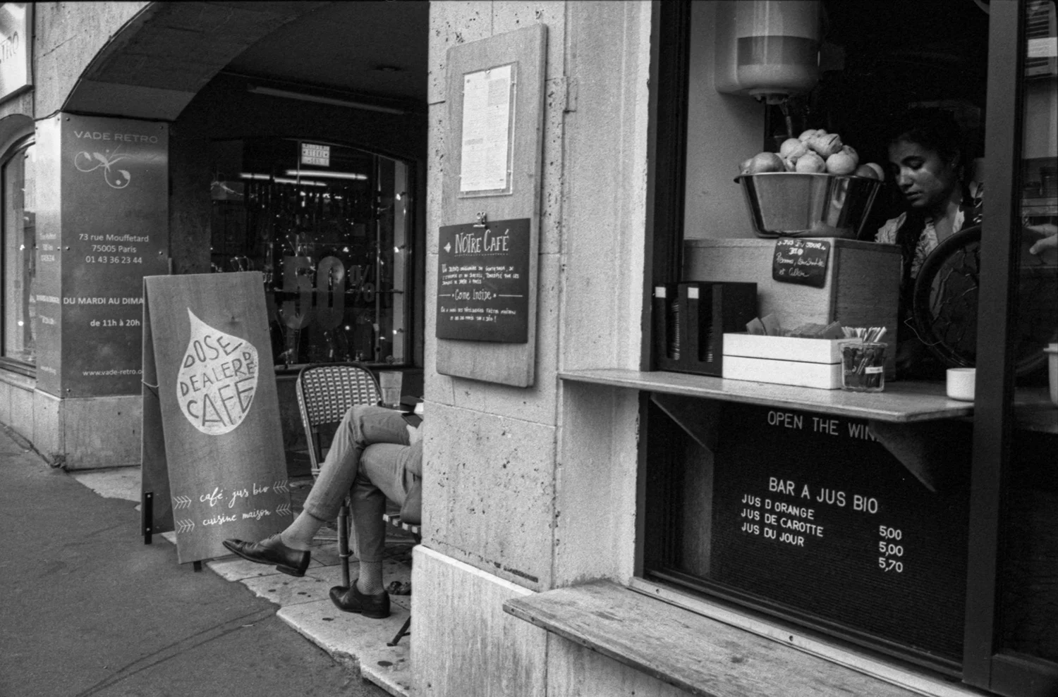 photo de rue Paris jambes hommes assis dans café et femme à l'intérieur